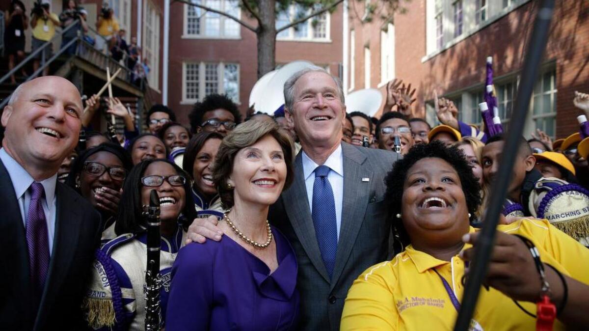 
George W. and Laura Bush and New Orleans Mayor Mitch Landrieu, far left, pose for a selfie with Asia Muhaimin, right, Aug. 28 in New Orleans.
