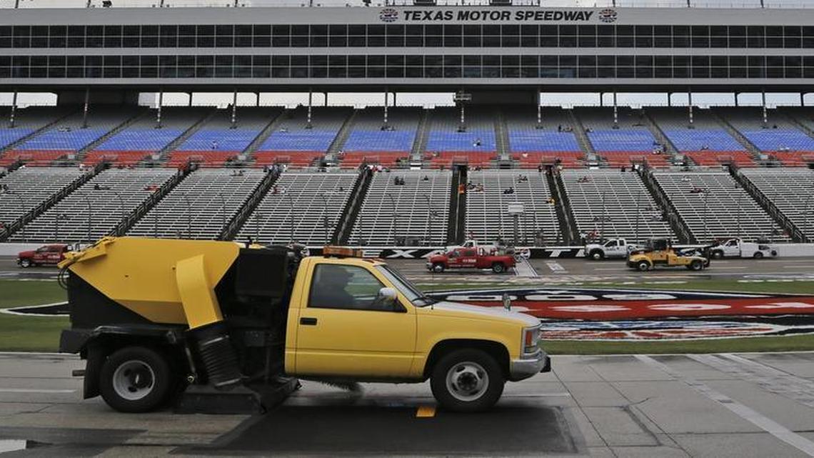 Trucks work to dry the track after a mid-afternoon thunderstorm Saturday soaked the track and delayed the start of the IndyCar Firestone 600 race at the Texas Motor Speedway. The race was postponed and rescheduled for 1:15 p.m. Sunday.