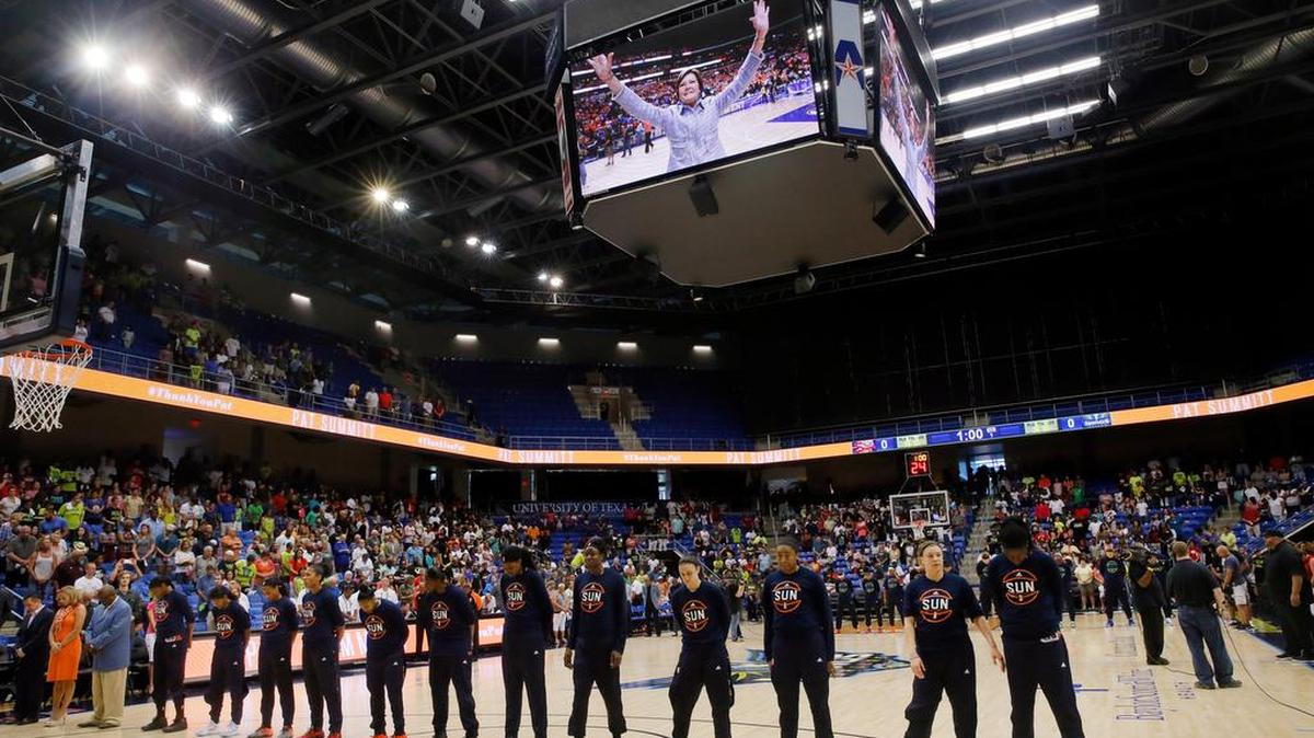 Connecticut Sun and Dallas Wings players stand on the court at College Park Center in Arlington during a moment of silence as the two teams recognize the recent passing of former Tennessee basketball coach Pat Summit, shown on video screen, before Saturday’s WNBA game.