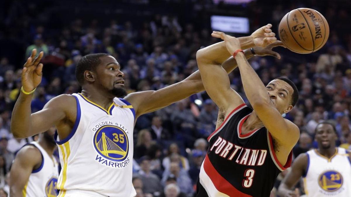 Golden State Warriors forward Kevin Durant, left, rejects Portland Trail Blazers guard C.J. McCollum during Wednesday’s game. Durant finished with three blocks, 30 points and five rebounds in the Warriors’ 125-117 victory. The Western Conference-leading Warriors next play host to the Memphis Grizzlies at 9:30 p.m. Friday on ESPN.