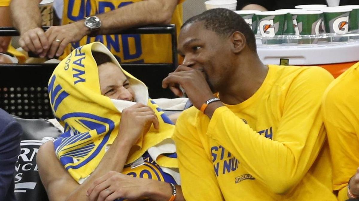 In closing minutes of their Game 3 victory, Golden State Warriors guard Stephen Curry, left, laughs with forward Kevin Durant. The Warriors will try to close out the San Antonio Spurs in Game 4 at 8 p.m. Monday on ESPN.