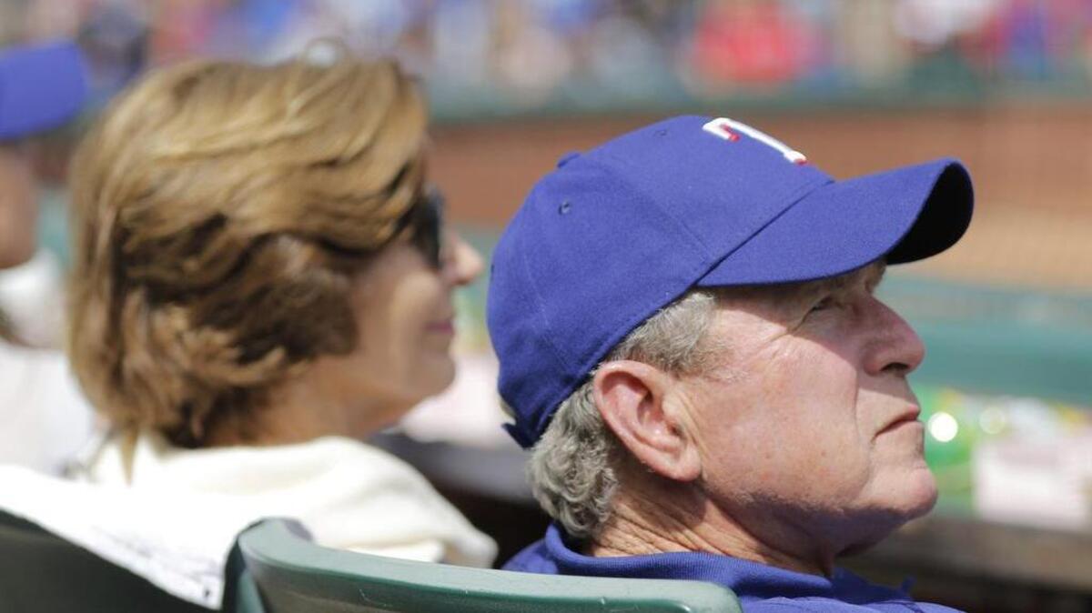 Former President George Bush and his wife Laura watch as the Houston Astros play the Texas Rangers on opening day.