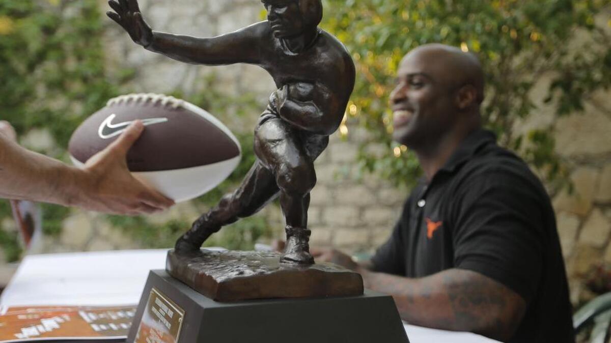 Ricky Williams, former Texas running back and Heisman Trophy winner, signs autographs as University of Texas coach Charlie Strong visits with fans at Joe T. Garcia's as part of “Texas comin' on Strong Tour” of the state to meet and talk with fans in 2014.