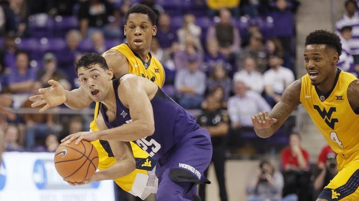 TCU guard Alex Robinson looks to pass as West Virginia forward Sagaba Konate, left, and guard Dexter Miles Jr. defend during the Horned Frogs’ 82-73 win Monday night.