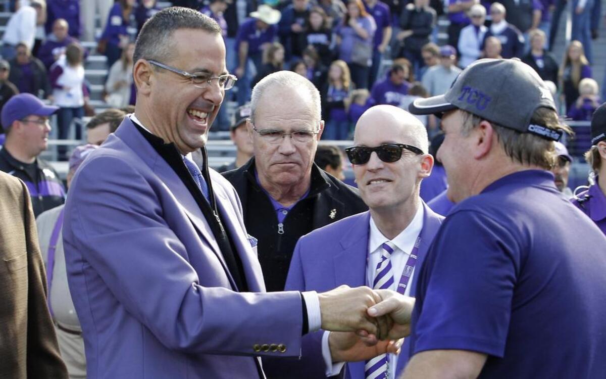 
TCU athletic director Chris Del Conte happily shakes the hand of football coach Gary Patterson during the Big 12 championship trophy presentation following the Horned Frogs’ 55-3 victory against Iowa State. The Horned Frogs wound up co-champions of the league in just their third season in the conference.
