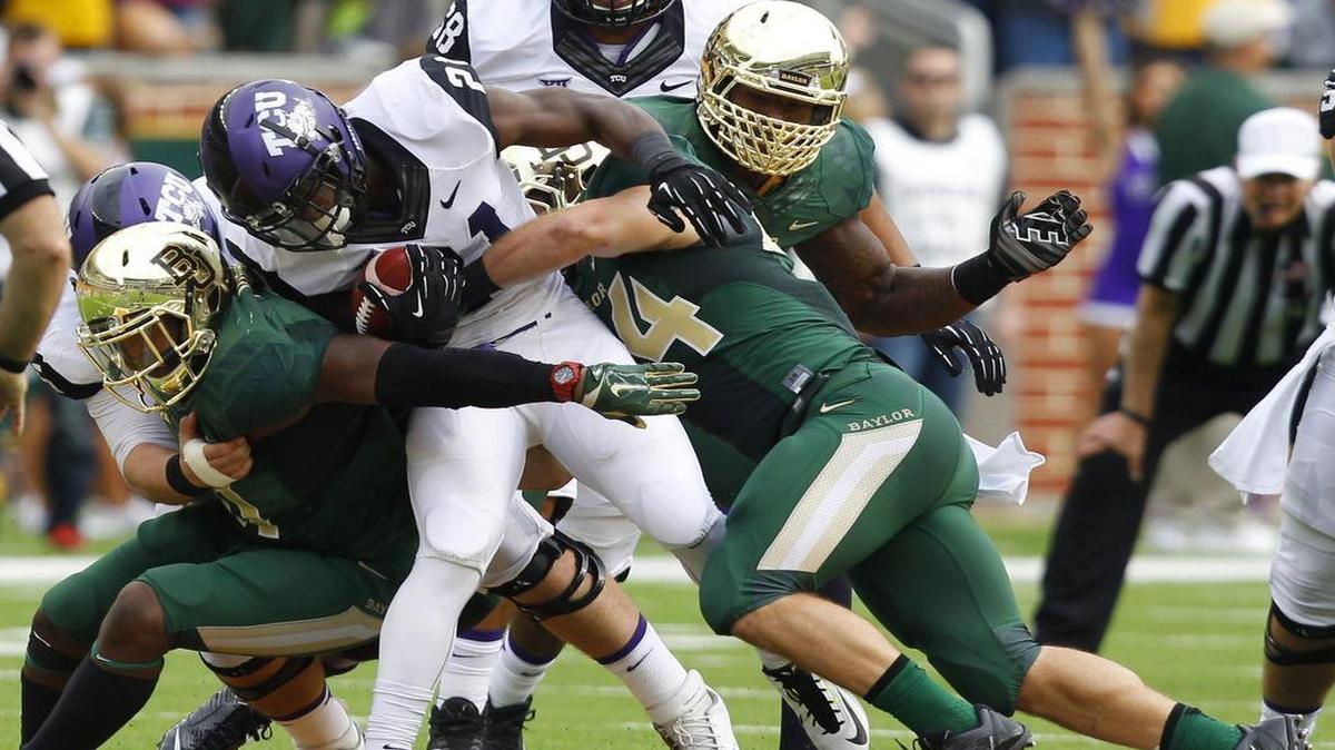 
TCU running back Kyle Hicks looks for an extra yard as he’s surrounded by Baylor defenders in last October’s shootout in Waco. The Horned Frogs and Bears lost only one game each last season and shared the Big 12 title. Next season, the conference will use a tiebreaker, if necessary, to crown one champ.
