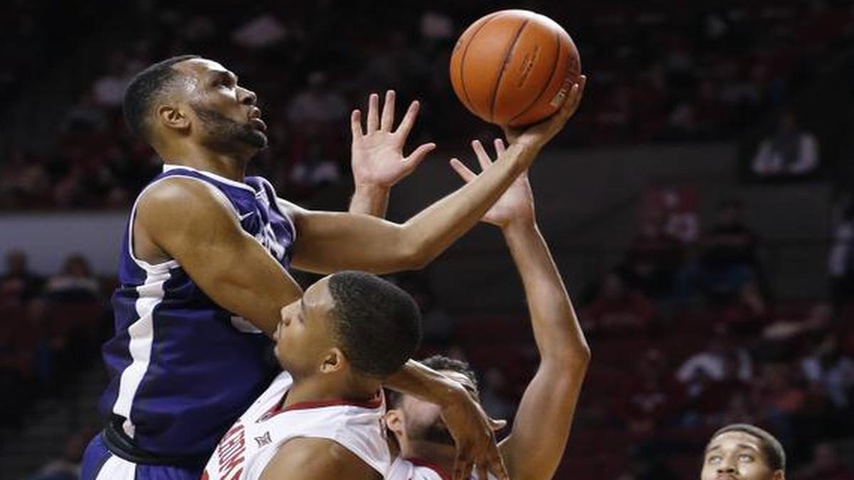 
TCU guard Trey Zeigler, left, shoots between Oklahoma forward TaShawn Thomas, center, and guard Frank Booker (1) in the first half of in Norman, Okla., on Saturday. Oklahoma guard Isaiah Cousins is at right. 
