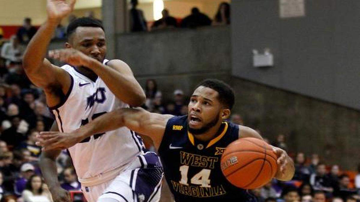 
West Virginia guard Gary Browne drives past TCU guard Trey Zeigler, left, during the second half of Saturday’s game at Wilkerson-Greines Activity Center. 
