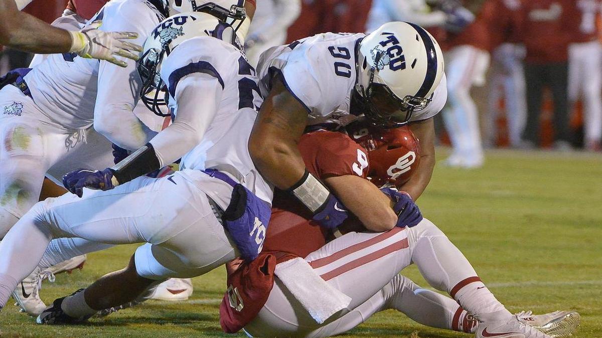 TCU defensive end Terrell Lathan stops Oklahoma quarterback Trevor Knight during the third quarter Saturday night. Trailing 30-13 in the fourth quarter, the Horned Frogs engineered a comeback that came up a point short.