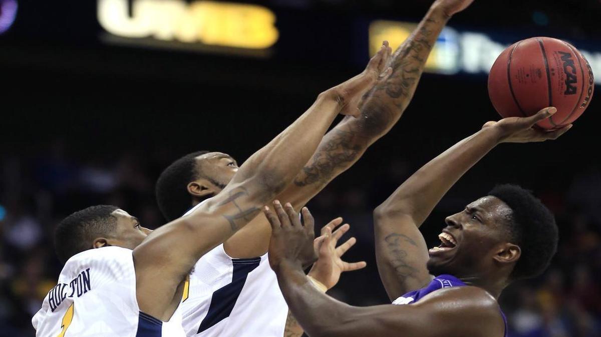 TCU forward JD Miller goes up for a shot against West Virginia’s Jonathan Holton and Elijah Macon during first-half action Thursday in the quarterfinals of the Big 12 tournament. Miller, a freshman from Seagoville, finished with 12 points and eight rebounds in the Horned Frogs’ 86-66 loss.
