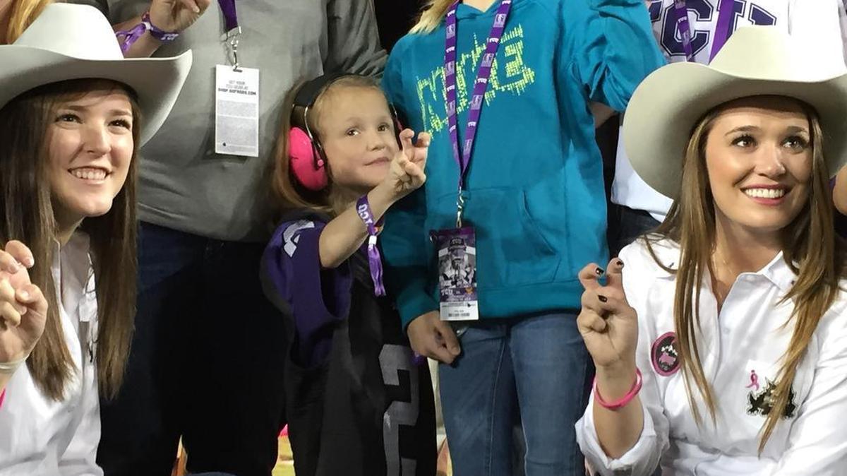 Abby Faber came out to cheers from the crowd at Amon G. Carter Stadium at the end of the first quarter Thursday night. She was joined by Kate Hults, left, and Kaitlyn Cosenza, who are part of the student group TCU Rangers.