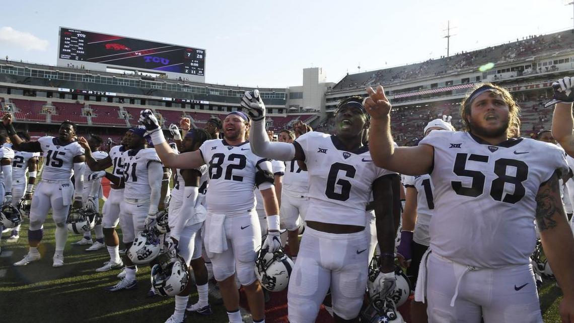 TCU players Charlie Reid (82), Darius Anderson (6) and Patrick Morris (58) celebrate the Horned Frogs’ 28-7 win against Arkansas Saturday afternoon at Razorback Stadium in Fayetteville, Ark.