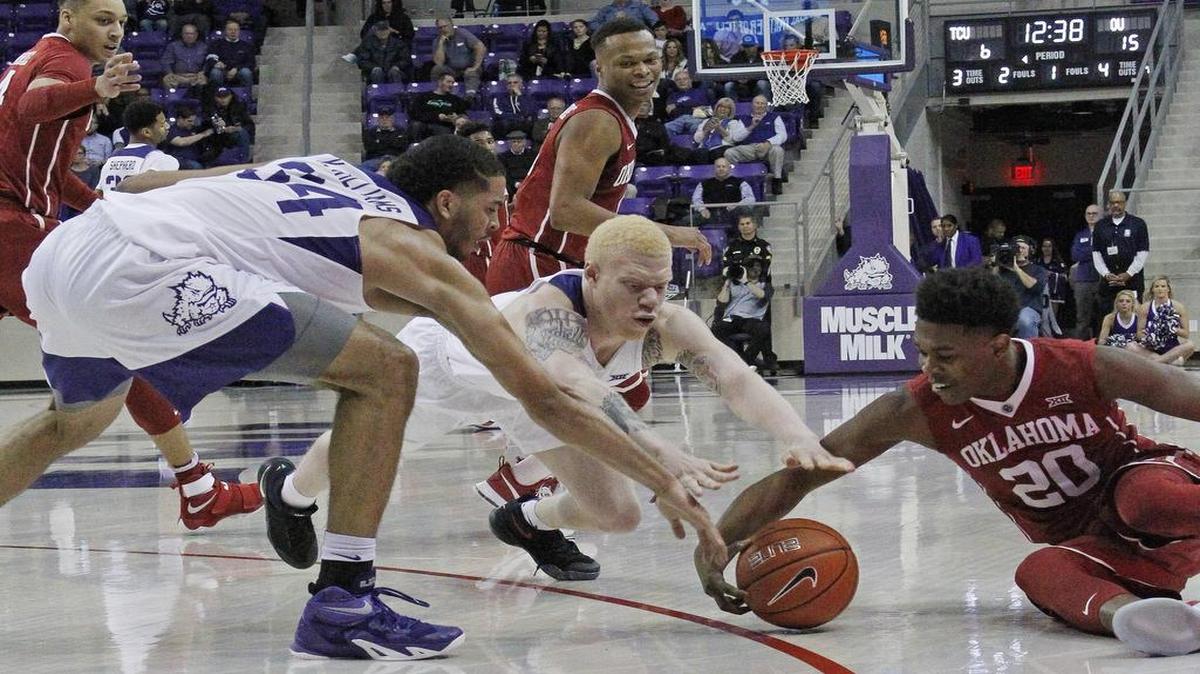 TCU’s Kenrich Williams, left, and Jaylen Fisher, middle, battle Oklahoma’s Kameron McGusty for a loose ball in first-half play Tuesday night. TCU improved to 12-2 and won its first Big 12 game of the season, 60-57 over the Sooners.