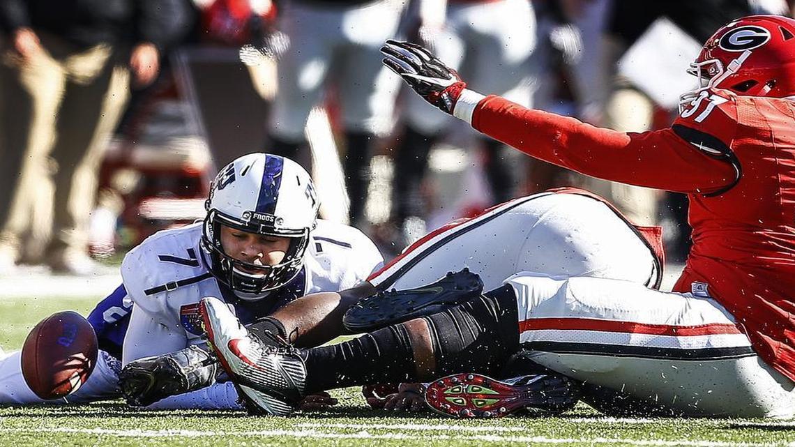 TCU quarterback Kenny Hill scrambles for the loose ball during second-quarter action Friday at the Liberty Bowl in Memphis. Georgia recovered, one of two turnovers by the Horned Frogs in their 31-23 loss.
