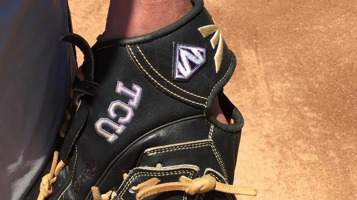 Brian Howard’s glove shows a patch with a logo and the letter M in a Superman emblem. The TCU baseball team is also wearing the patch on its caps.