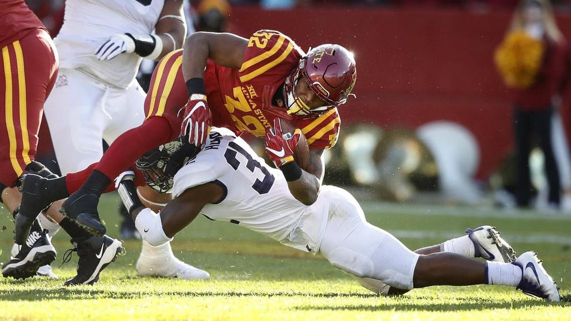 Iowa State running back David Montgomery is brought down by TCU linebacker Travin Howard during second-half action Saturday in Ames, Iowa.