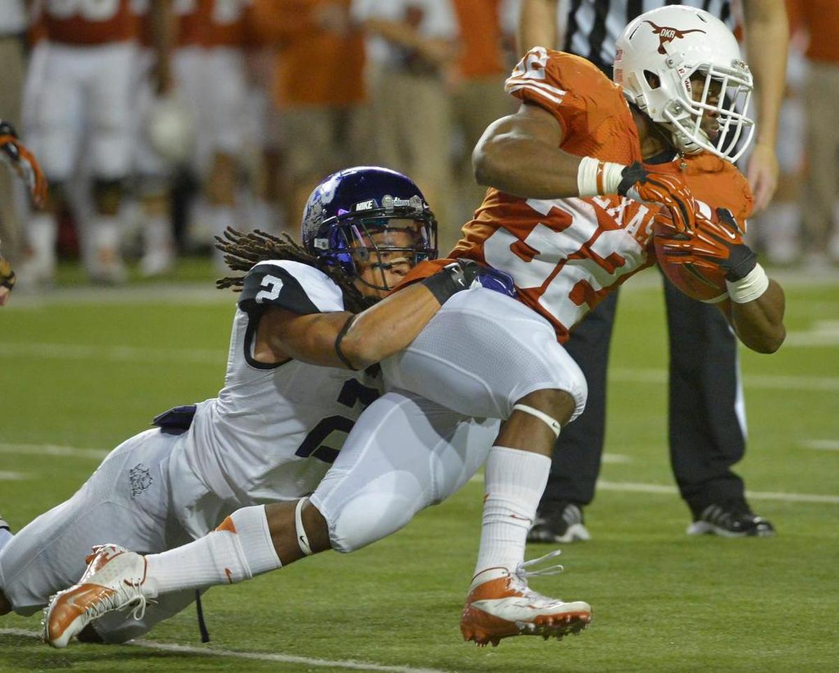 Longhorns running back Johnathan Gray, right, gets dragged down from behind by TCU cornerback Jason Verrett during the Horned Frogs’ 20-13 win against Texas in Austin on Thanksgiving night, Nov. 22, 2012.