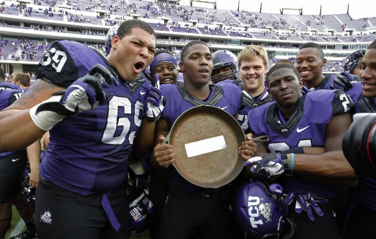 TCU Horned Frogs offensive tackle Aviante Collins, quarterback Trevone Boykin and running back Kyle Hicks celebrate with the Iron Skillet in 2013.
