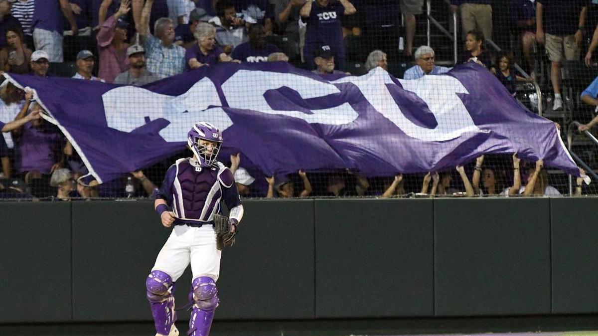 TCU fans display a school flag behind catcher Evan Skoug at the start of the fourth inning in Monday night’s Fort Worth Regional championship game against Dallas Baptist.