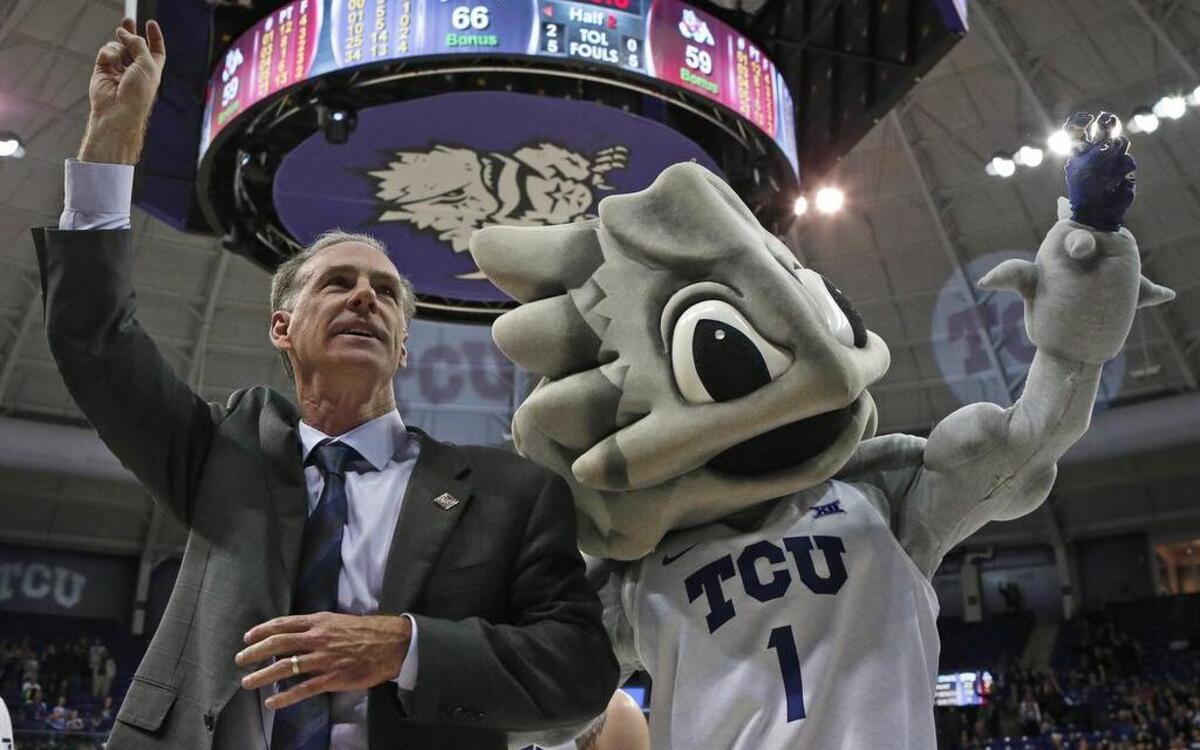 TCU coach Jamie Dixon stands with Super Frog in the celebration following a victory against Fresno State in the first round of the NIT at Schollmaier Arena on March 15.