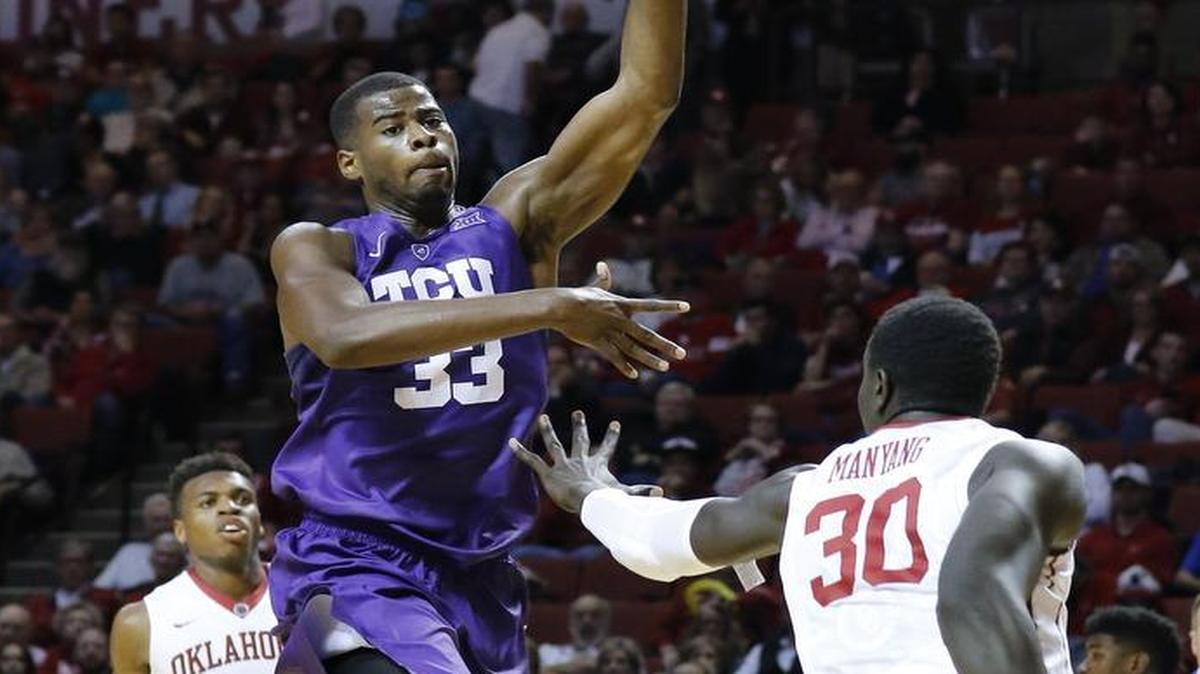 TCU forward Chris Washburn pushes the ball to the basket against the defense of Oklahoma center Akolda Manyang during first-half action Tuesday night in Norman, Okla.
