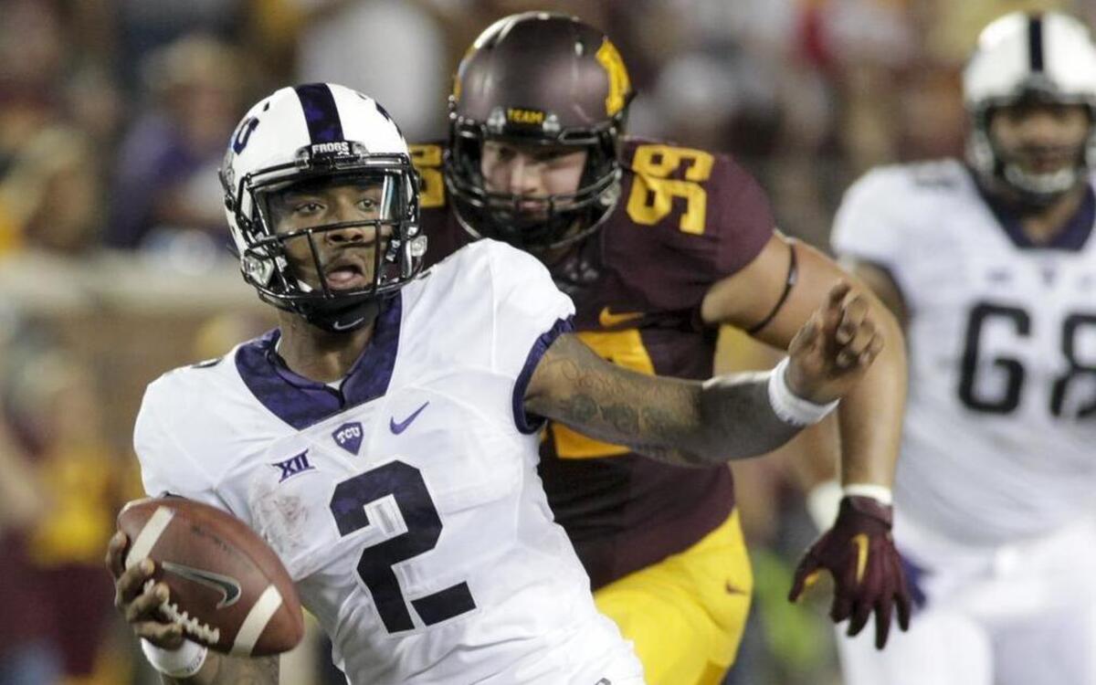 
TCU quarterback Trevone Boykin evades the tackle of Minnesota offensive lineman Matt Leidner during the first half.
