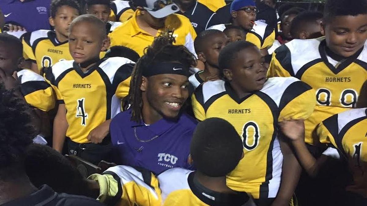 TCU safety Caylin Moore poses for photographs with a youth football team following a talk with the players from him and other Horned Frogs players on Oct. 10 at O.D. Wyatt High School. The effort was part of an outreach program he founded.