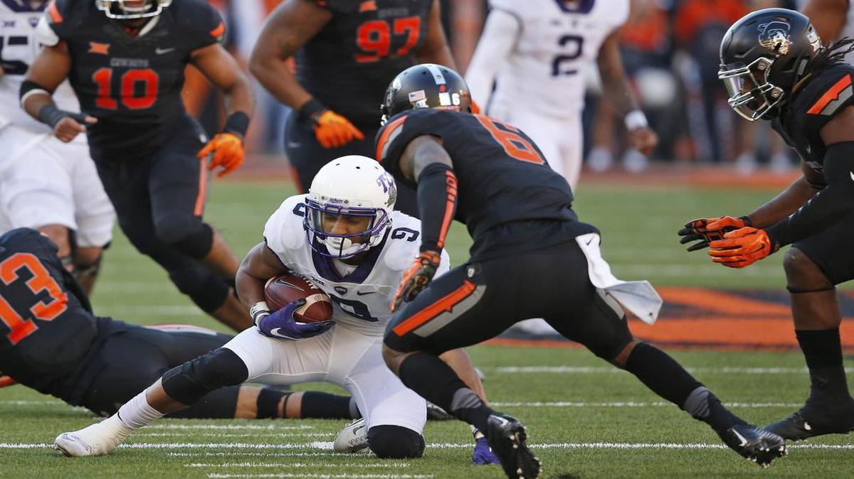 Oklahoma State cornerback Ashton Lampkin moves in with other defenders to tackle TCU wide receiver Josh Doctson, who was injured on the play.