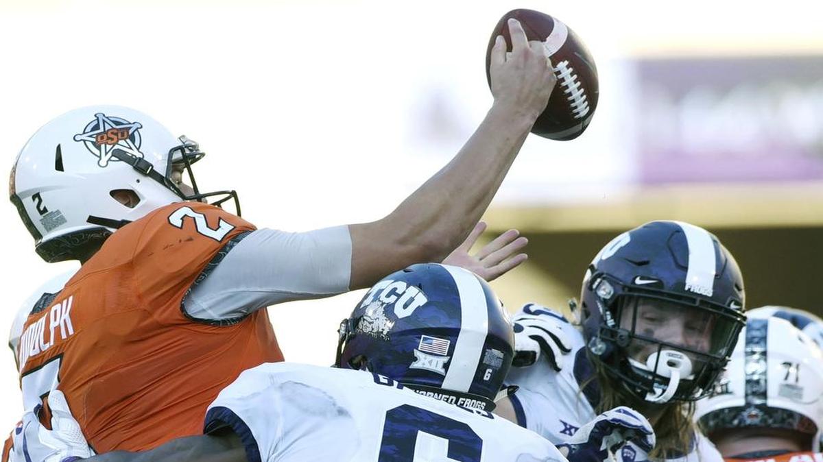Oklahoma State quarterback Mason Rudolph takes pressure from TCU safety Innis Gaines (6) and defensive end Mat Boesen in the second half Saturday at Boone Pickens Stadium. The play resulted in an interception by defensive end LJ Collier.