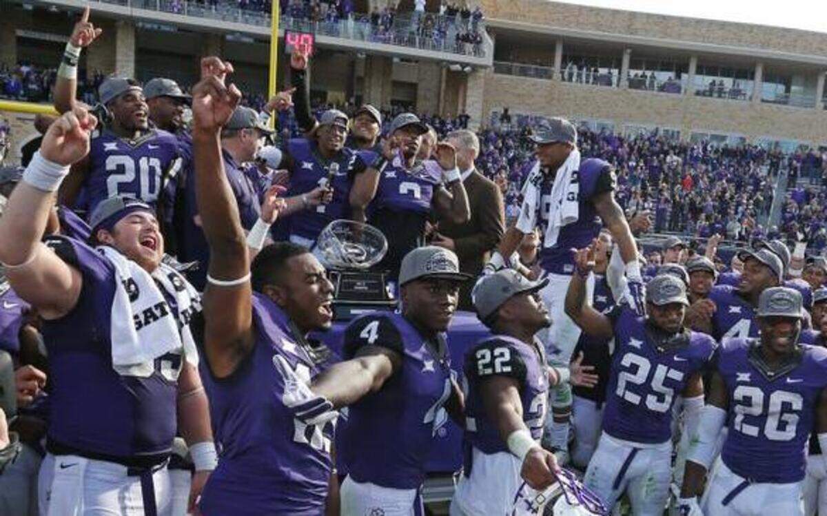 
TCU players gather around the Big 12 trophy after the presentation as TCU beats Iowa State 55-3 in Fort Worth, Texas, Saturday, December 6, 2014. 
