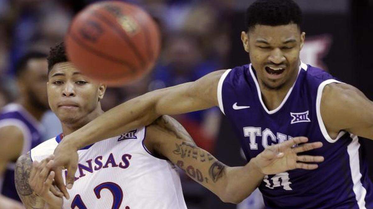 
Kansas guard Kelly Oubre Jr. (12) tangles with TCU center Karviar Shepherd (14) while chasing a loose ball.
