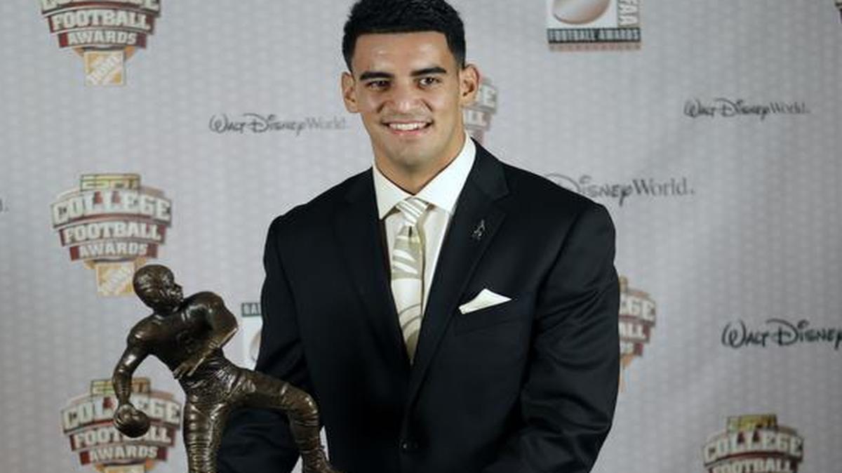 
Oregon’s Marcus Mariota stands with his trophy after being awarded the Davey O’Brien National Quarterback Award for at the College Football Awards, Thursday, Dec. 11, 2014, in Lake Buena Vista, Fla. 
