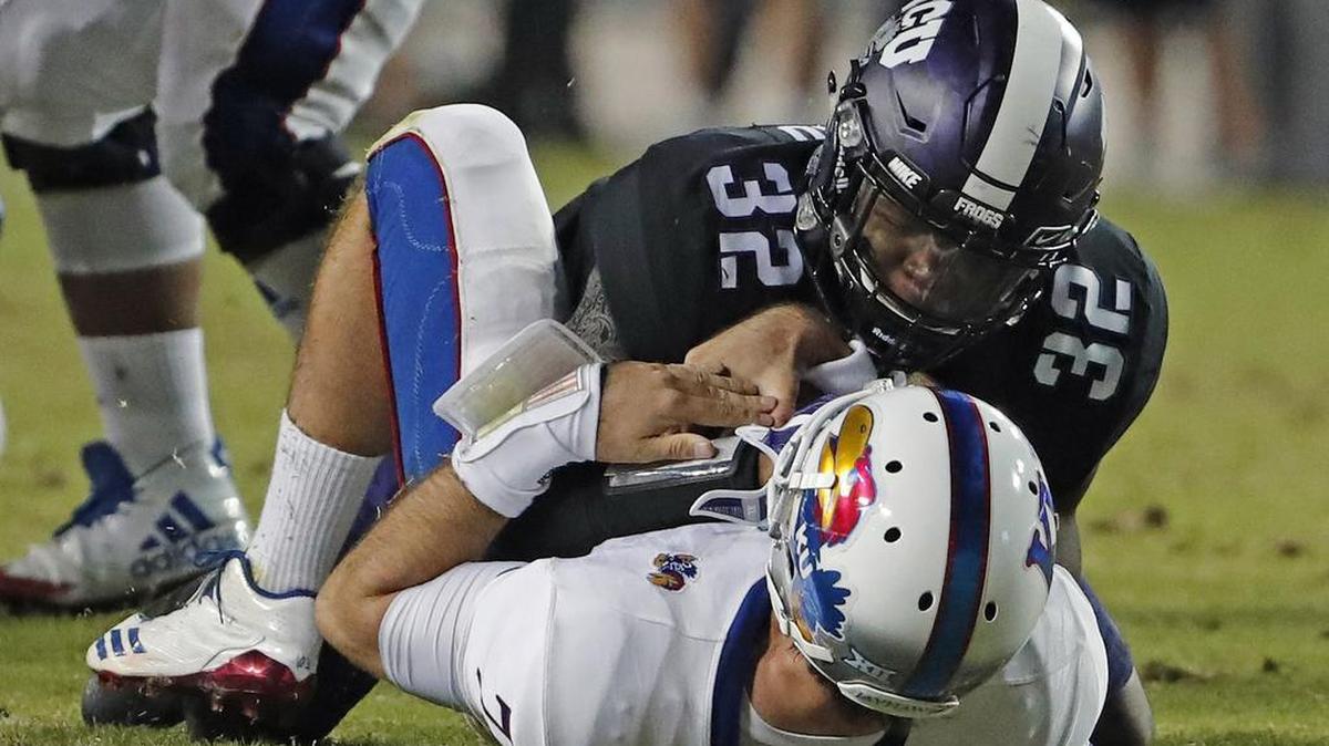 TCU linebacker Travin Howard completes a takedown of Kansas quarterback Peyton Bender for one of the Horned Frogs’ four sacks in a 43-0 victory on Oct. 21 at Amon G. Carter Stadium.