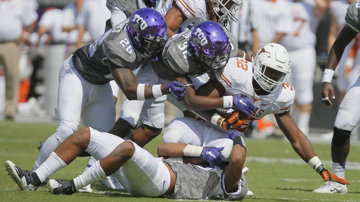 TCU defenders Derrick Kindred (left) and Travin Howard bring down Texas running back Johnathan Gray during first-half action on Oct. 3, 2015, at Amon G. Carter Stadium. The teams will play their 2017 game in Fort Worth at 6:15 p.m. on Nov. 4, televised by ESPN.