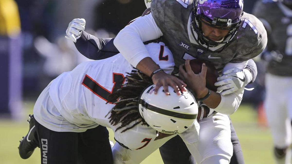 TCU quarterback Kenny Hill is caught in a tackle by Oklahoma State defenders, led by cornerback Ramon Richards, in the 2016 game at Amon G. Carter Stadium. Oklahoma State won 31-6.