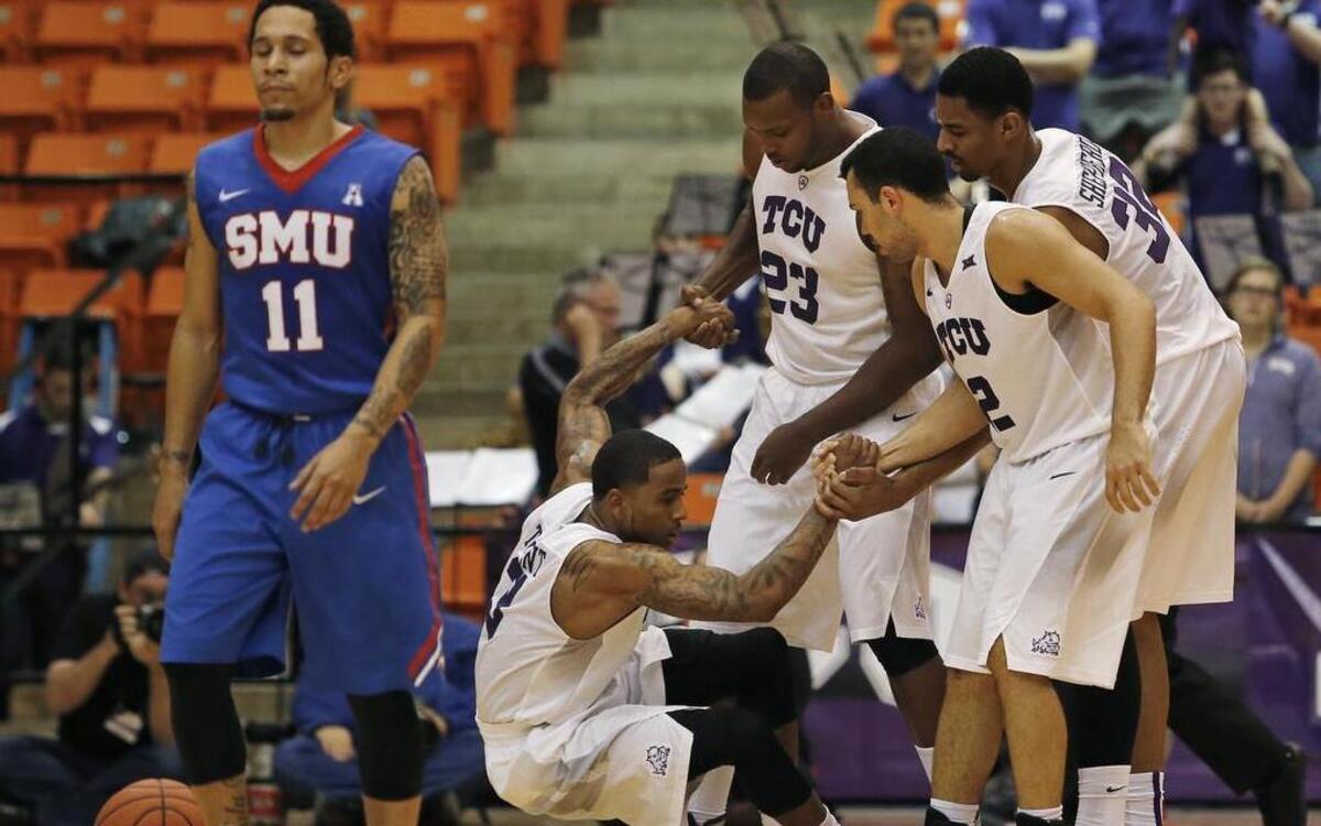 TCU guard Malique Trent is helped up by teammates after drawing a foul in a Dec. 2 game against SMU. He scored 13 points and had five assists in the Horned Frogs’ 75-70 loss.