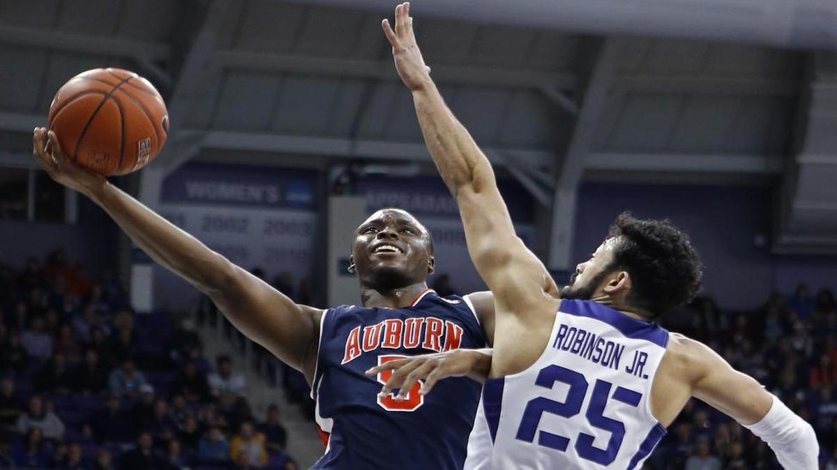 Auburn Tigers freshman guard Mustapha Heron, left, shoots around the defense of TCU’s Alex Robinson. Heron had 17 points, one of four Auburn freshmen in double figures, as the Tigers beat TCU 88-80 on Saturday.