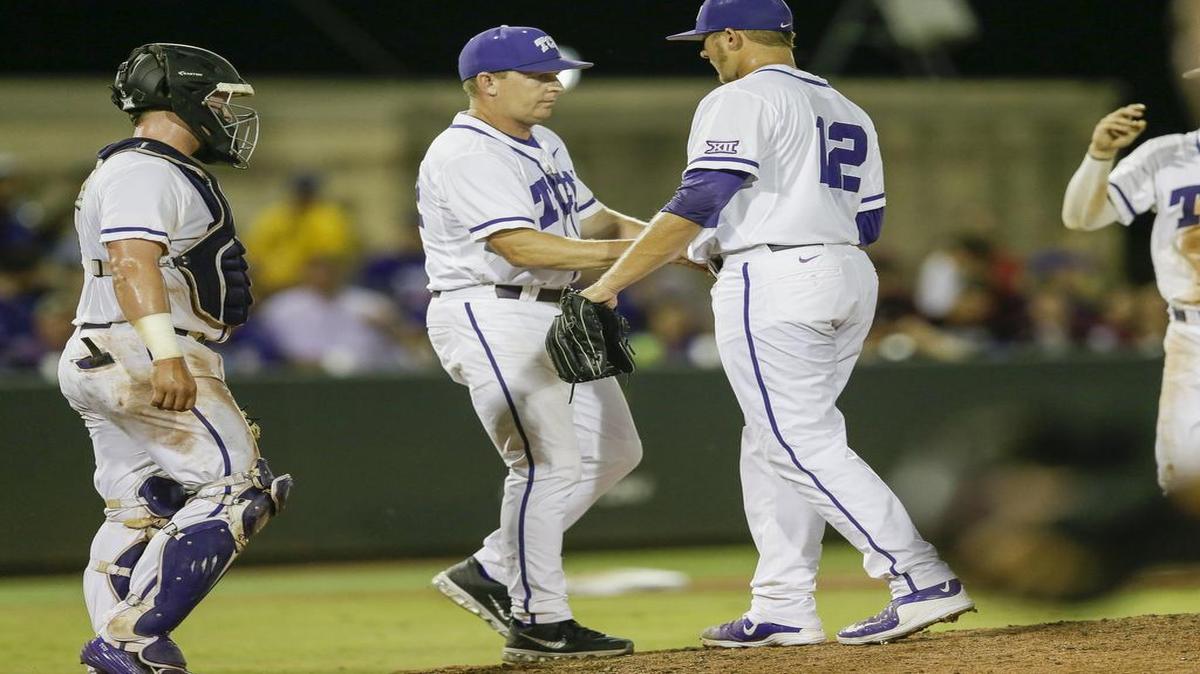 
TCU coach Jim Schlossnagle, left, takes the ball from Riley Ferrell in the ninth inning Monday night. Ferrell hit a batter and walked a batter to start the inning against Texas A&M in the Super Regional finale.
