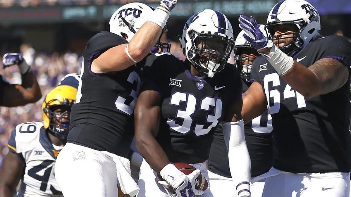TCU running back Sewo Olonilua celebrates with teammates after scoring the first touchdown in Saturday’s 31-24 Horned Frogs’ victory against West Virginia.