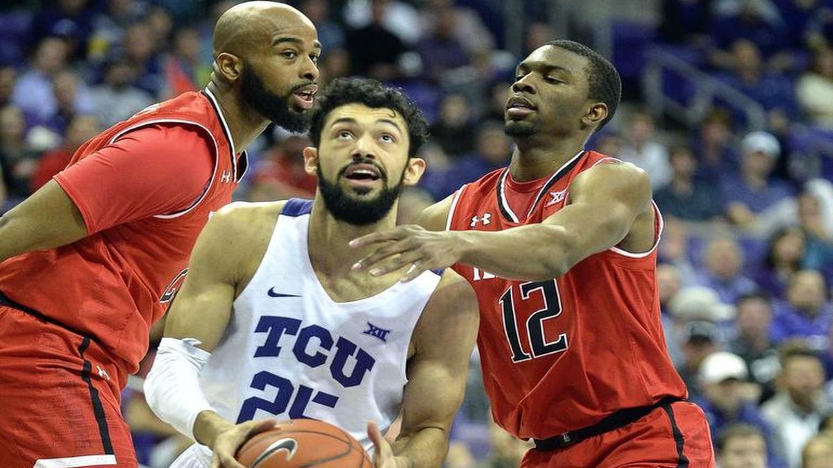 TCU guard Alex Robinson (25) splits Texas Tech forward Anthony Livingston and guard Keenan Evans during Tuesday’s game.