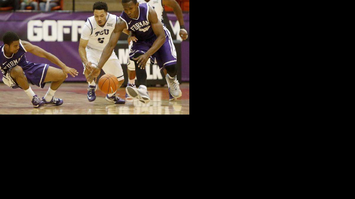 
TCU guard Kyan Anderson scrambles for a loose ball against Furman’s John Davis III, left, and Kevin Chuisseu.
