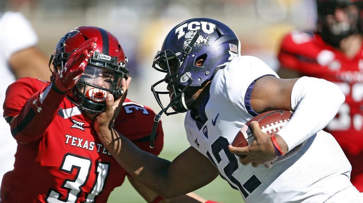 TCU quarterback Shawn Robinson moves to stiff-arm past Texas Tech defender Justus Parker during second-half action of a Big 12 game at Jones AT&T Stadium in Lubbock on Nov. 18. It was the first start by a freshman quarterback under Gary Patterson. Robinson and the Horned Frogs won 27-3.