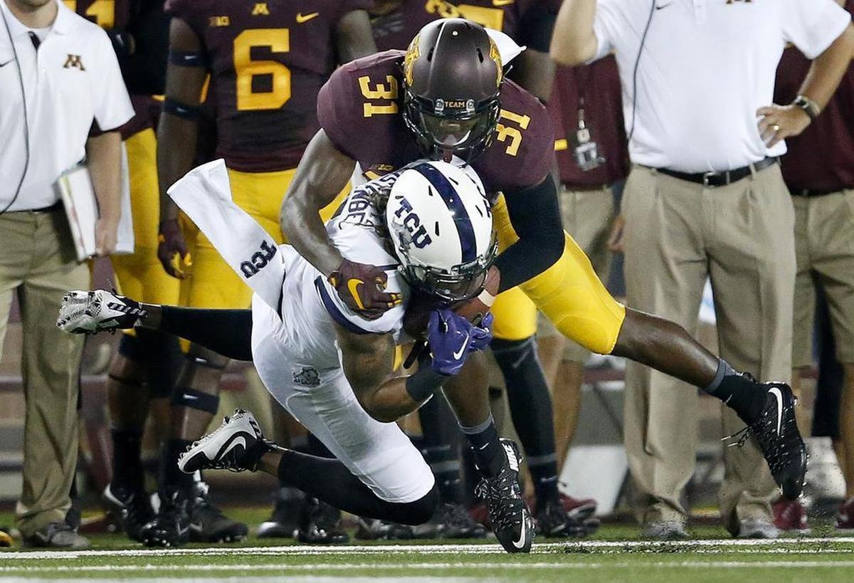 Minnesota’s Eric Murray tackles Kolby Listenbee of TCU.