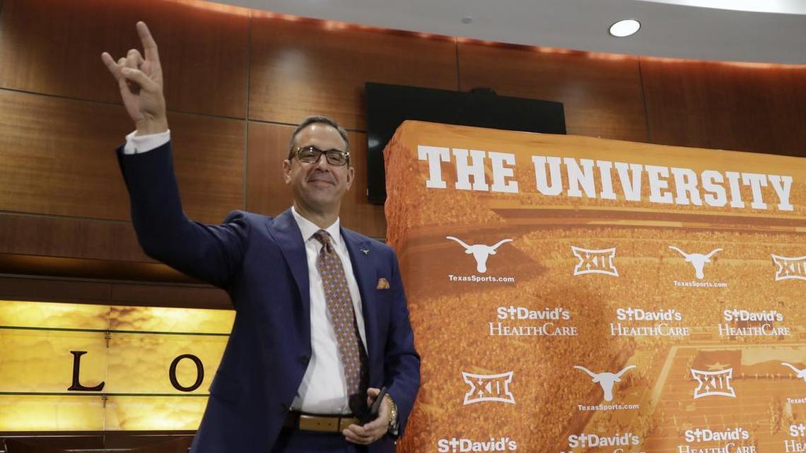 Chris Del Conte holds up the Hook ’em sign at a news conference where he was introduced as athletic director for the University of Texas on Monday in Austin.
