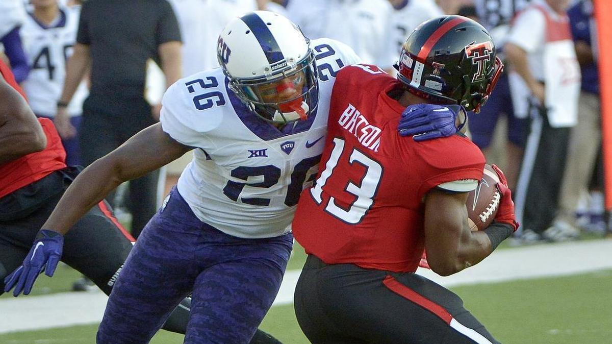 TCU safety Derrick Kindred, left, wrapping up Texas Tech’s Kolin Hill this season, said he was determined to fight through the pain to set an example for his younger teammates.