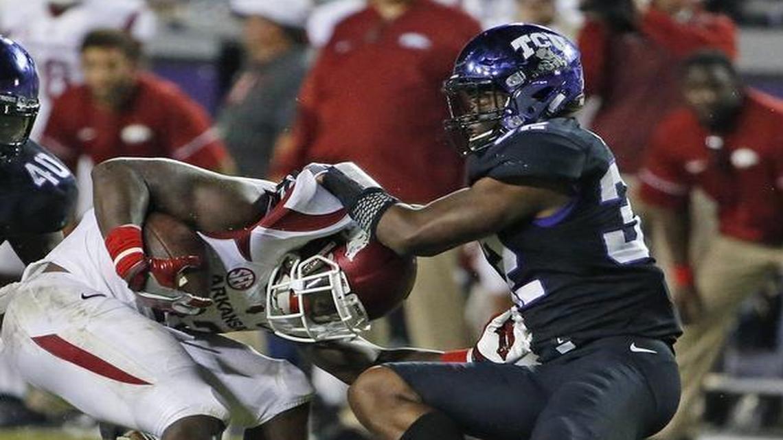 TCU linebacker Travin Howard (right) helps with a stop of Arkansas running back Rawleigh Williams III in the fourth quarter of a Sept. 10 game at Amon G. Carter Stadium.