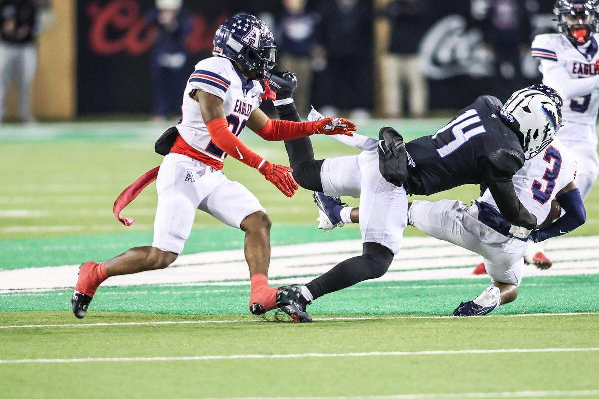 North Crowley’s Zion Miller (14) tackles Allen’s Caleb Smith during the Class 6A Division I regional final Friday at DATCU Stadium in Denton.
