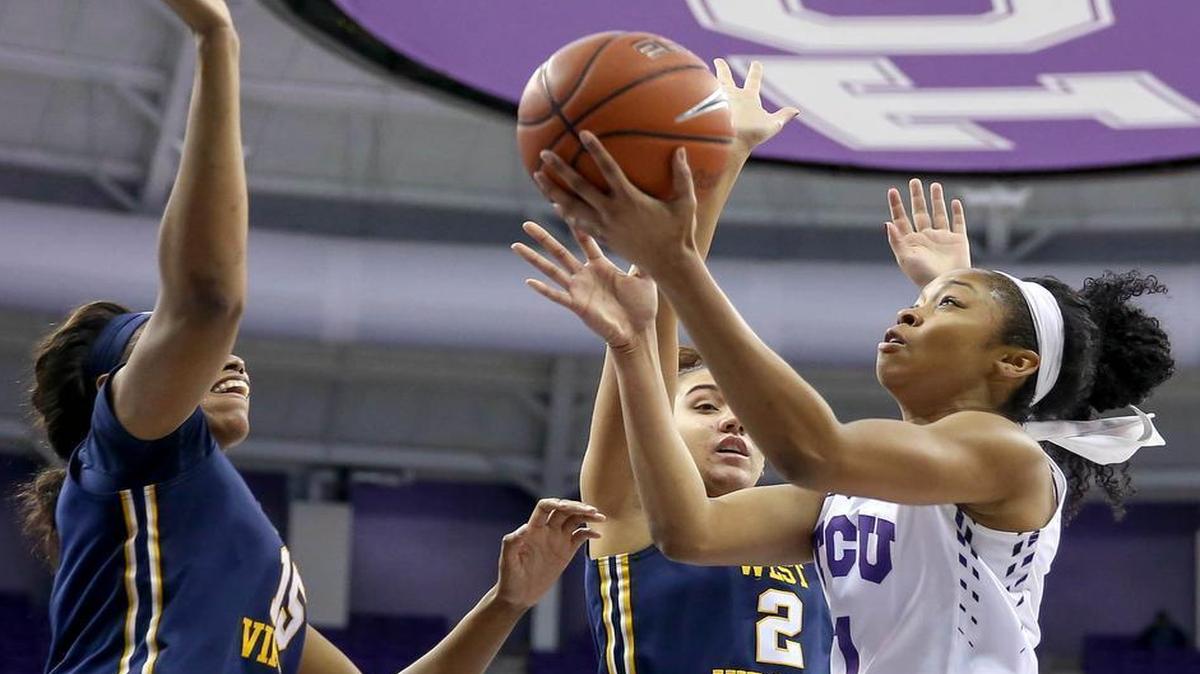 TCU guard Toree Thompson (1) drives to the basket against West Virginia center Lanay Montgomery (15) and guard Alexis Brewer (2) during the second half.