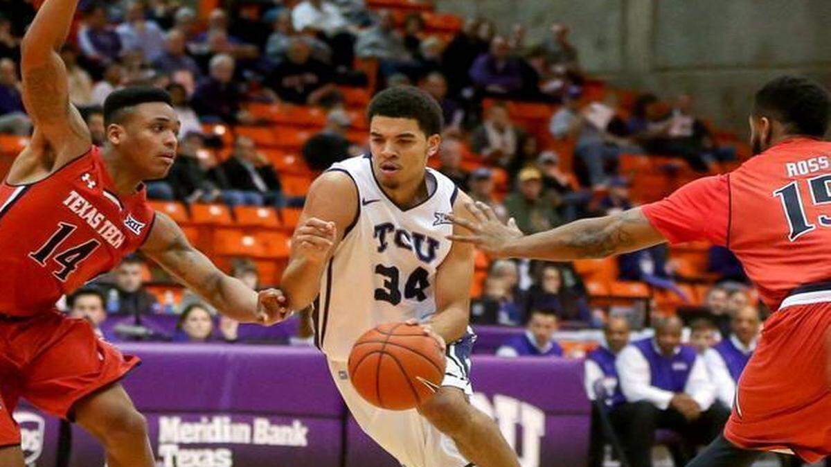
TCU forward Kenrich Williams  looks to drive past Texas Tech guard Robert Turner (14) and Aaron Ross (15) during the first half Wednesday night. 
