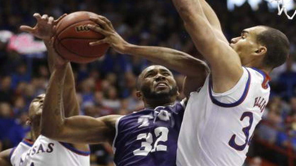 
TCU guard Trey Zeigler (32) shoots between Kansas defenders Devonte Graham (4) and Perry Ellis (34) during the second half at Allen Fieldhouse in Lawrence, Kan., Saturday. Zeigler scored 20 points in the game. Kansas defeated TCU 81-72. 
